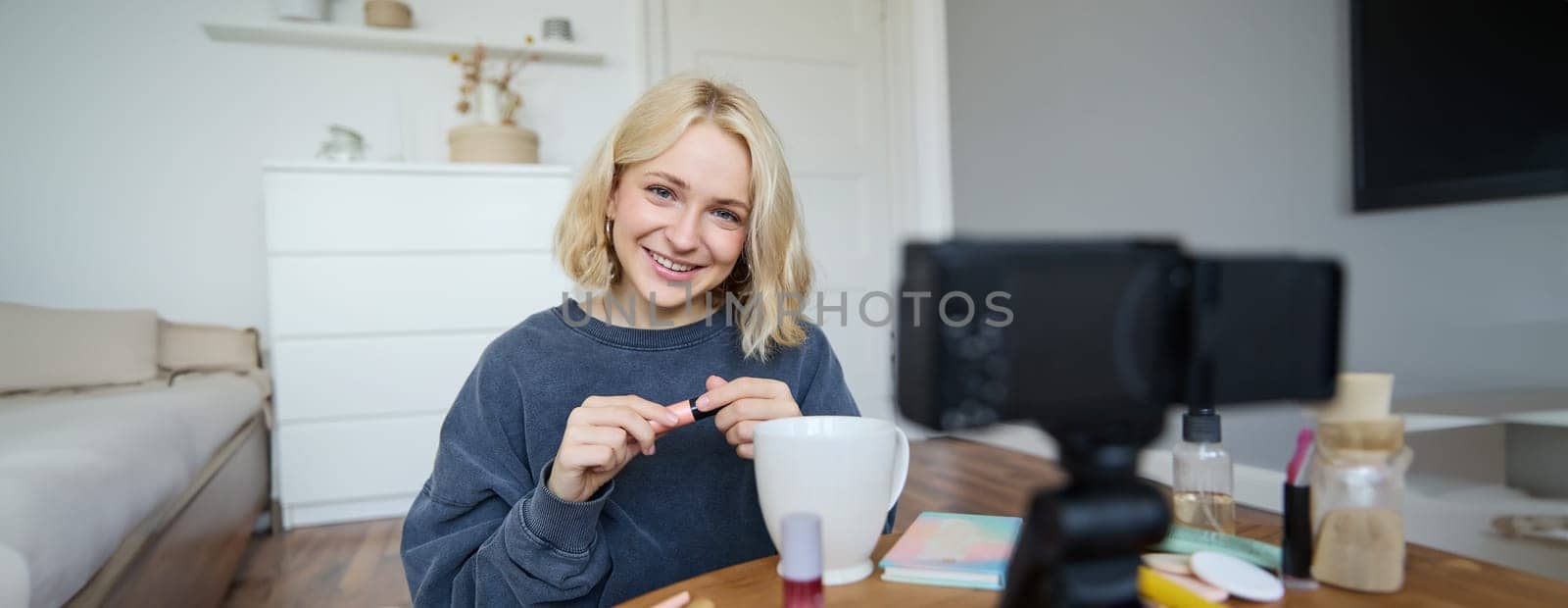 Young charismatic beauty blogger, teenage girl records video of her applying mascara, reviewing makeup products for her lifestyle vlog, vlogging for social media account by Benzoix