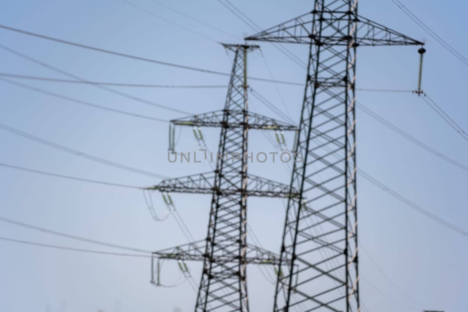 High voltage towers with sky background. Power line support with wires for electricity transmission. High voltage grid tower with wire cable at distribution station. Energy industry, energy saving by Matiunina