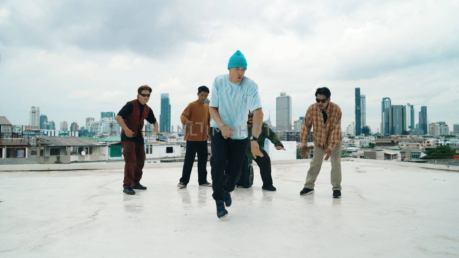 Professional break dance team practice B-boy dance while multicultural friends at rooftop. Young modern dancing group doing hip hop movement. Style,fashion,action. Outdoor sport 2024. Endeavor.