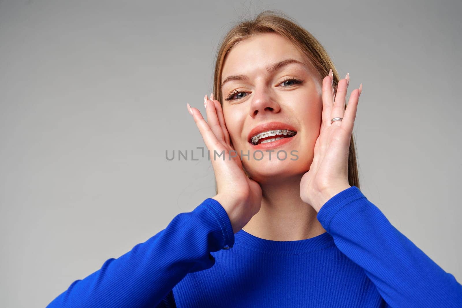Young Woman Expressing Surprise or Confusion Against a Grey Background in studio