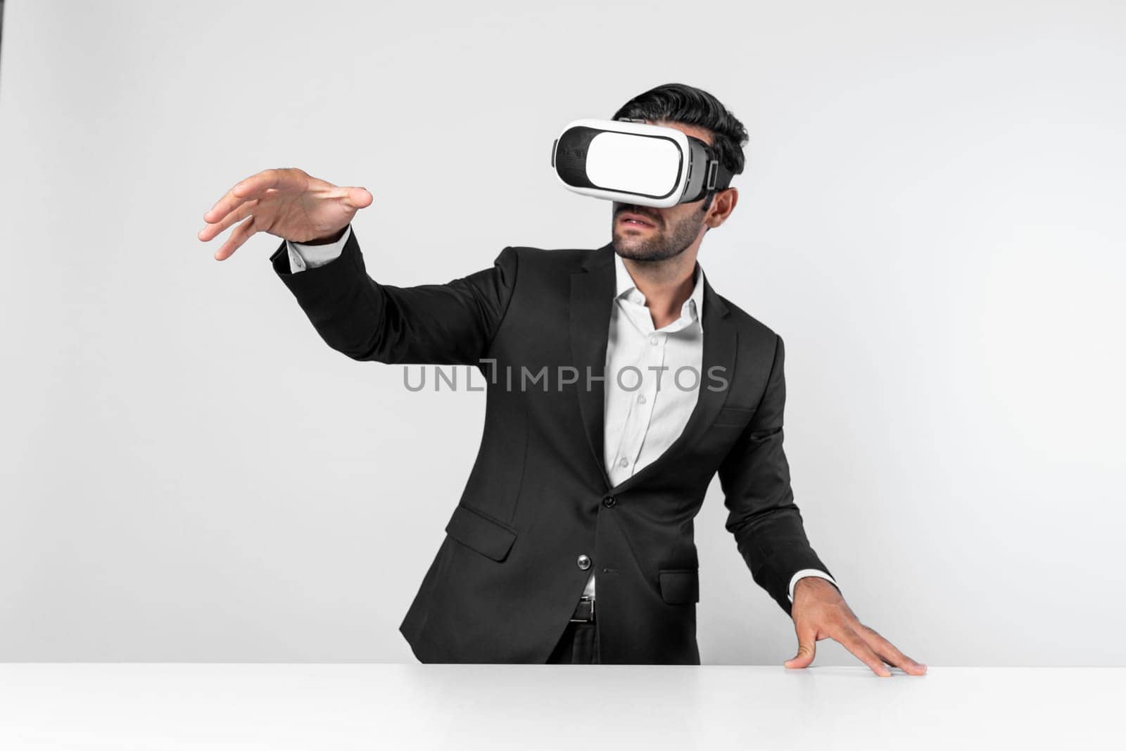 Smart businessman standing at table with laptop while choosing data analysis by using technology innovation. Skilled caucasian project manager using virtual reality glasses and VR goggles. Deviation.