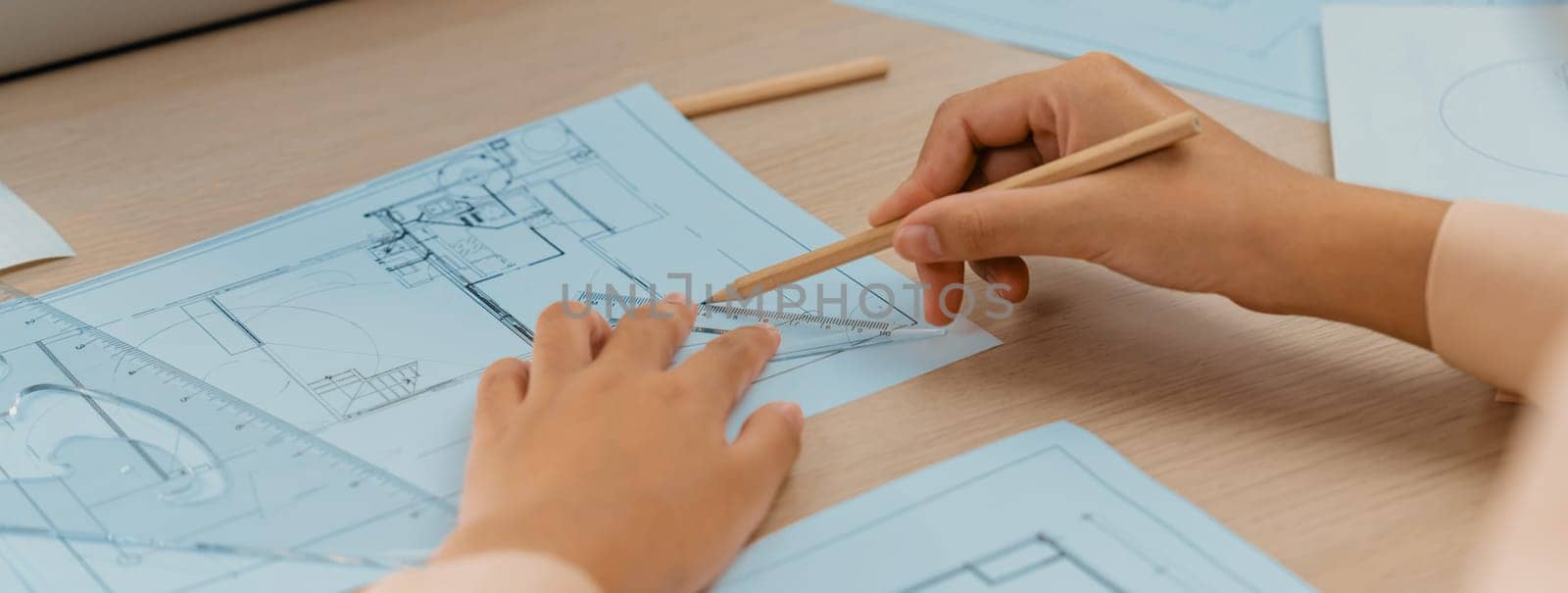 Professional architect hand drawing a blueprint on table. Closeup. Delineation. by biancoblue