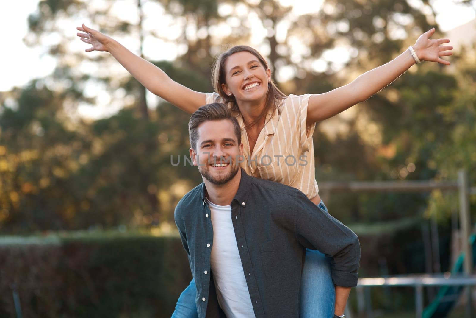 Man, woman and portrait with piggyback outdoor for relationship connection, anniversary or celebration. Happy couple, face and romance date in garden with airplane game for fun, playing or bonding.