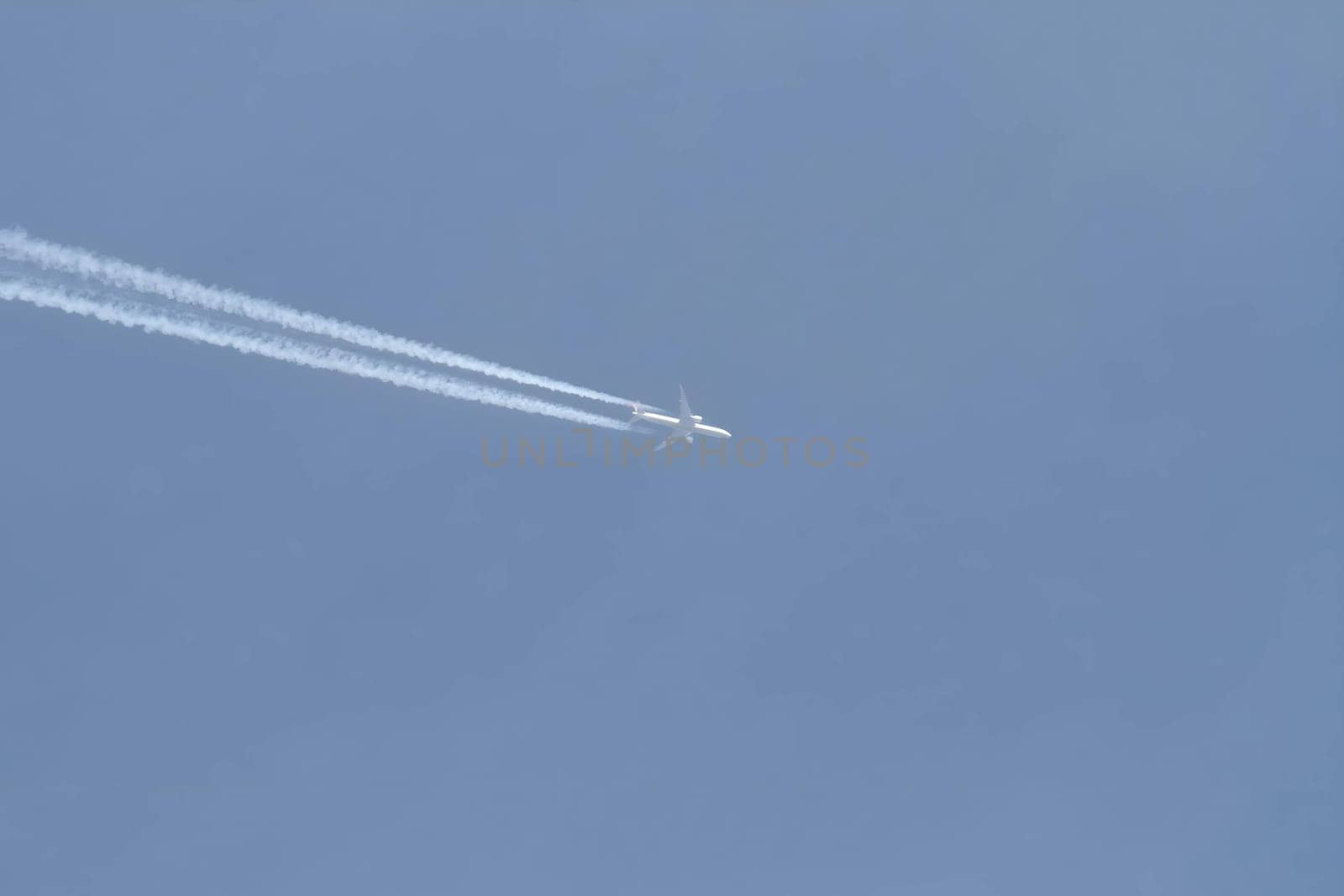 A gleaming white plane soaring gracefully in the vast sky.