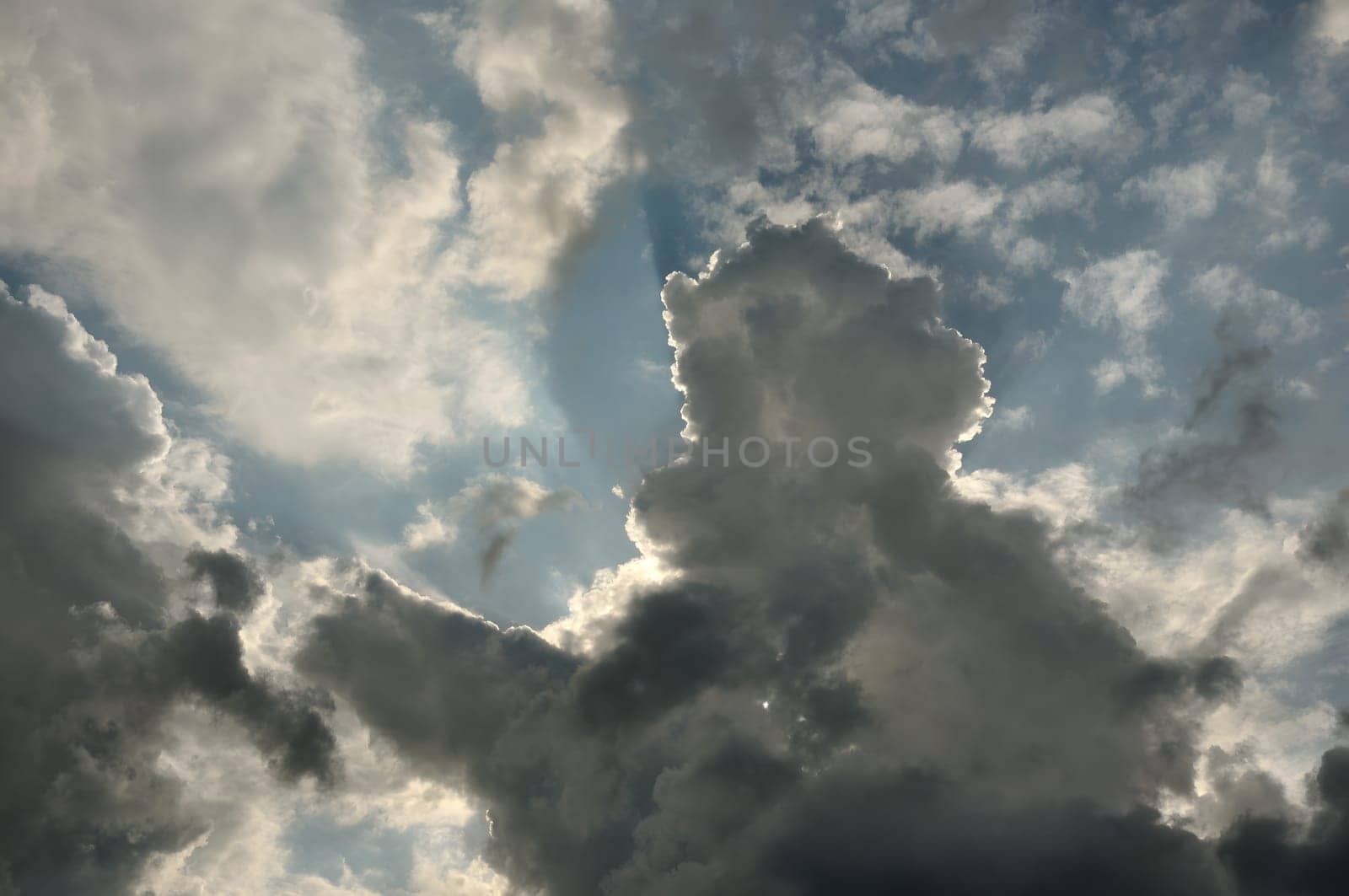 The sky is adorned with clouds, and the sun gently peeks through, casting a warm glow, creating a serene and picturesque scene.