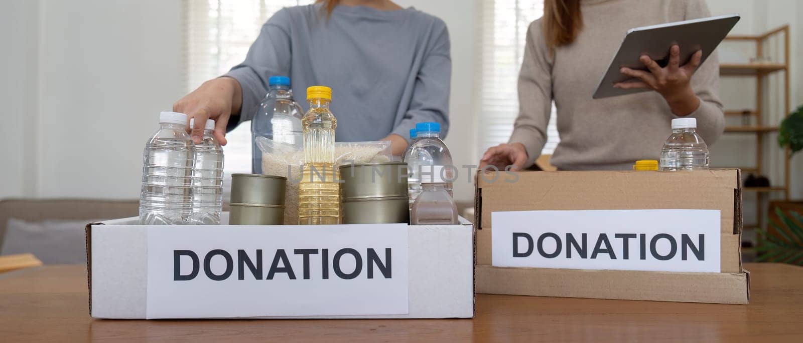 Volunteer preparing free foodstuff rations for poor people. Charity two woman of the community work together. concept of giving and humanitarian aid.