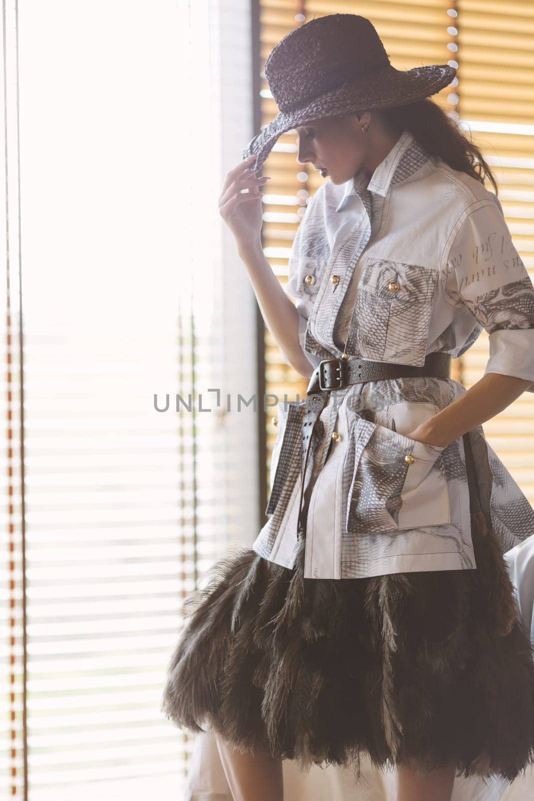 Indoor portrait of a young beautiful fashionable woman wearing stylish accessories. Hidden eyes with hat. Female fashion, beauty and advertisement concept. Close up. Copy space for text.