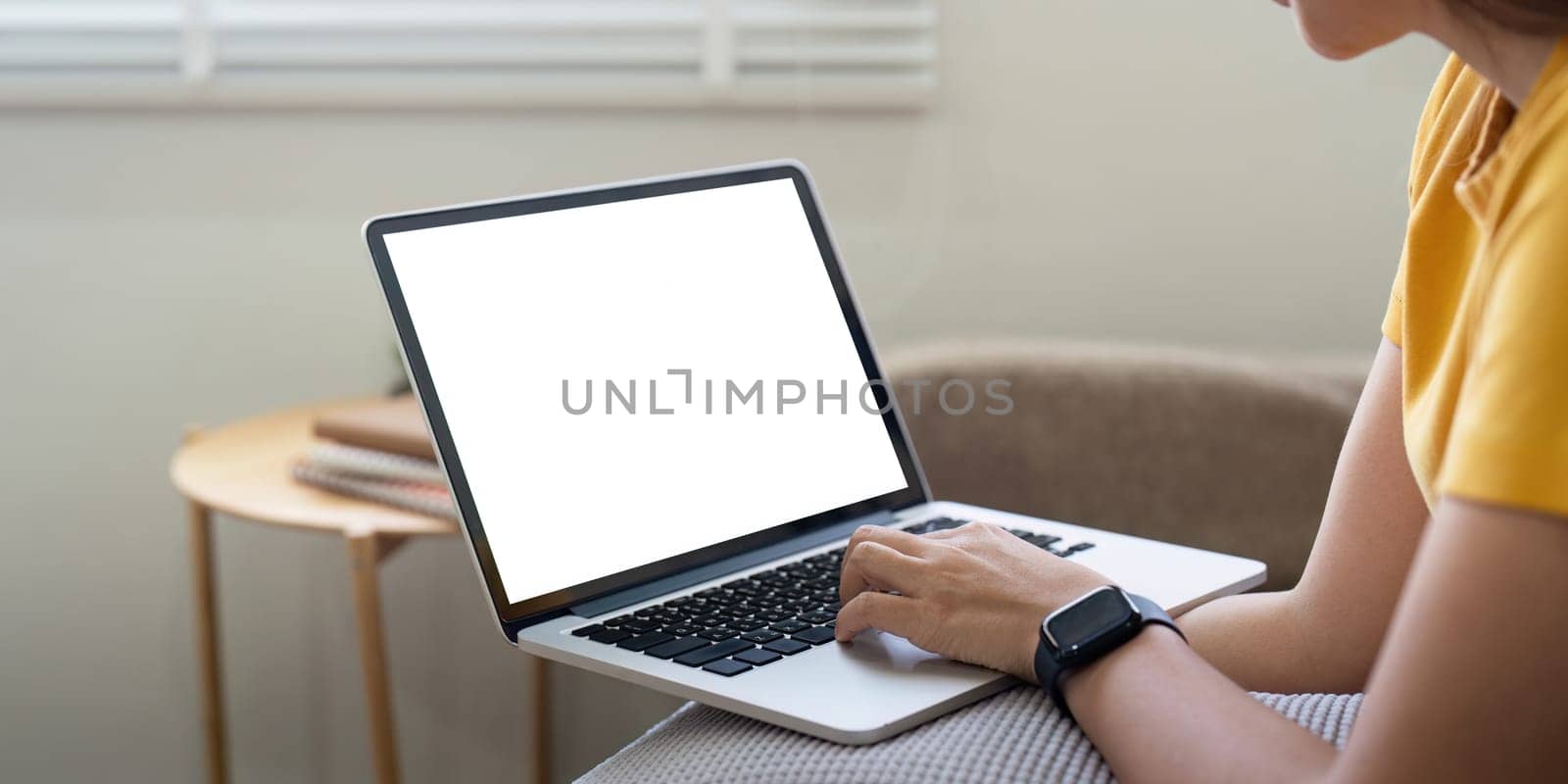 Young female with laptop at home on white blank screen for montage mockup display device in concept of lifestyle work at home.