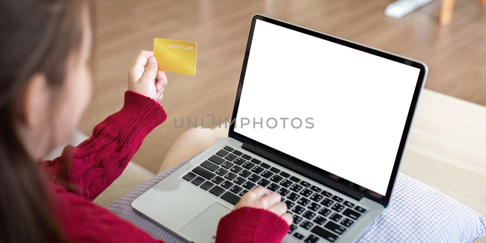 Happy female shopper customer holding credit card paying online on laptop mock up white screen shopping in web store making digital payment on website by nateemee