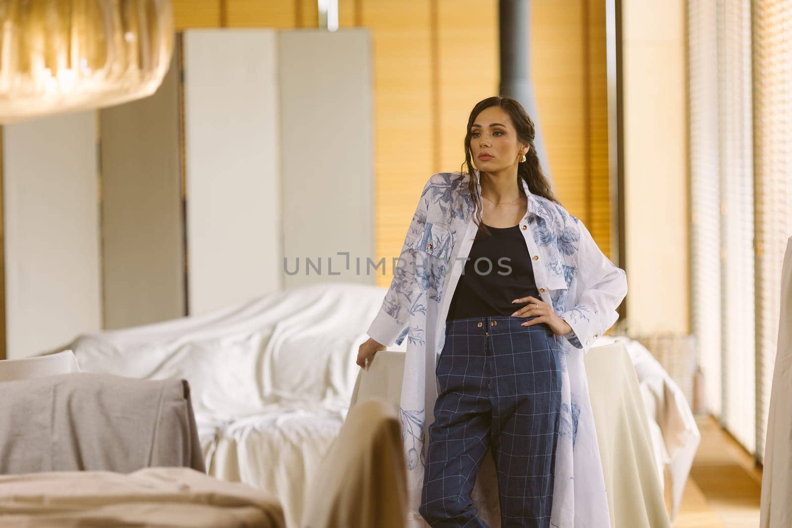 Fashionable confident woman wearing elegant suit, trousers posing in interior. Studio fashion portrait.