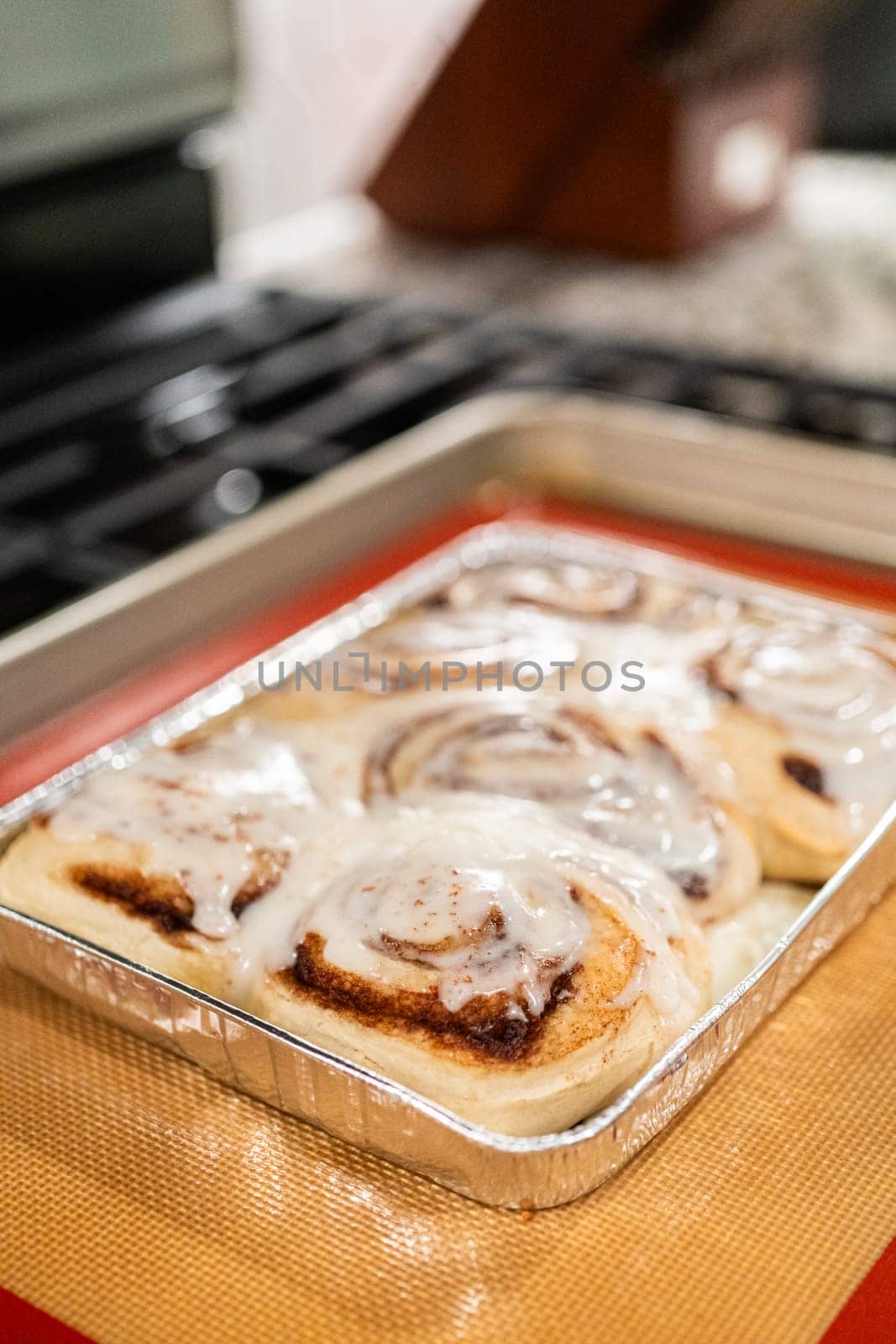 Freshly Baked Cinnamon Rolls Cooling on Stove Top by arinahabich