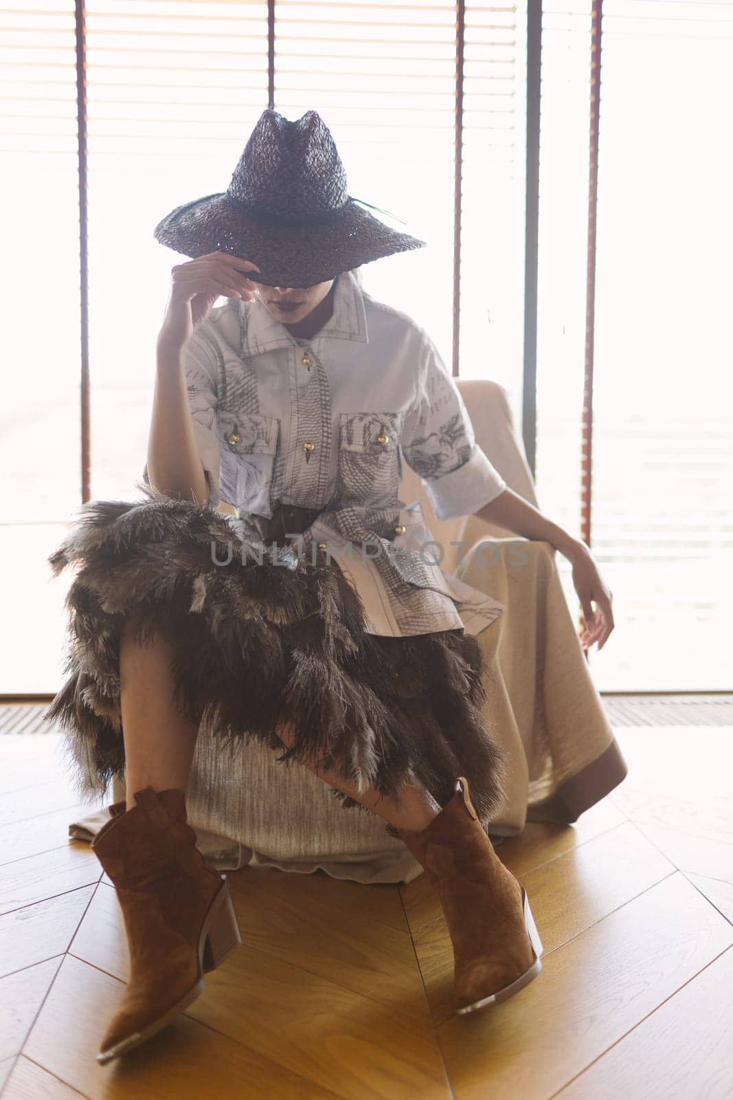 Indoor portrait of a young beautiful fashionable woman wearing stylish accessories. Hidden eyes with hat. Female fashion, beauty and advertisement concept. Close up. Copy space for text.