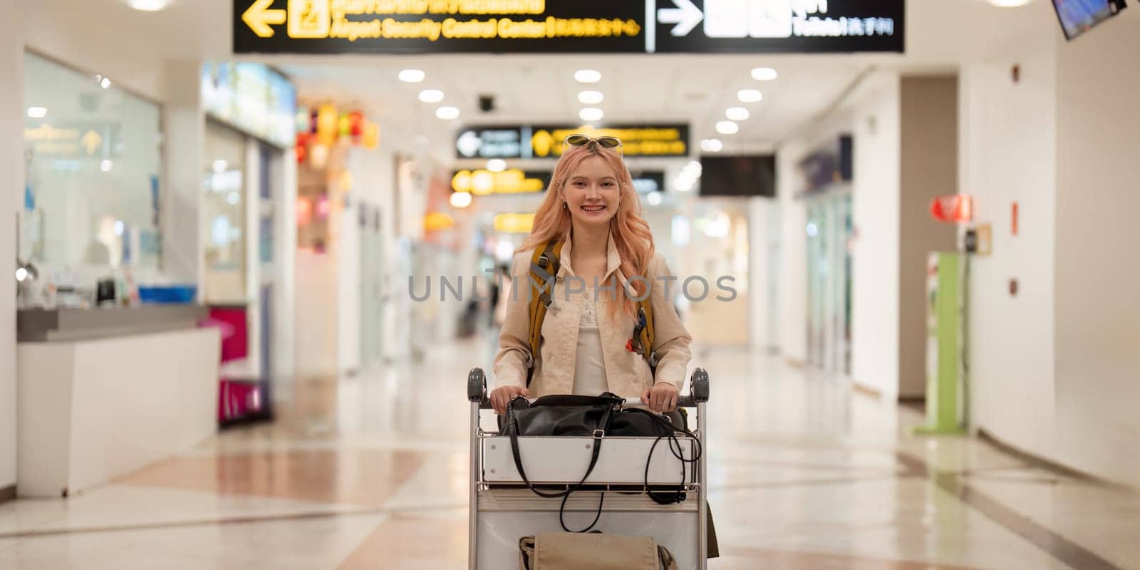 Happy asian tourist woman with backpack and luggage traveling between waits for flight in airport terminal, Tourist journey trip concept by nateemee