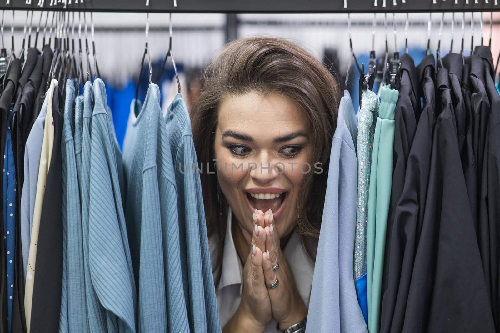 A fat woman in a plus size store peeks out from behind racks of clothes. by mrwed54