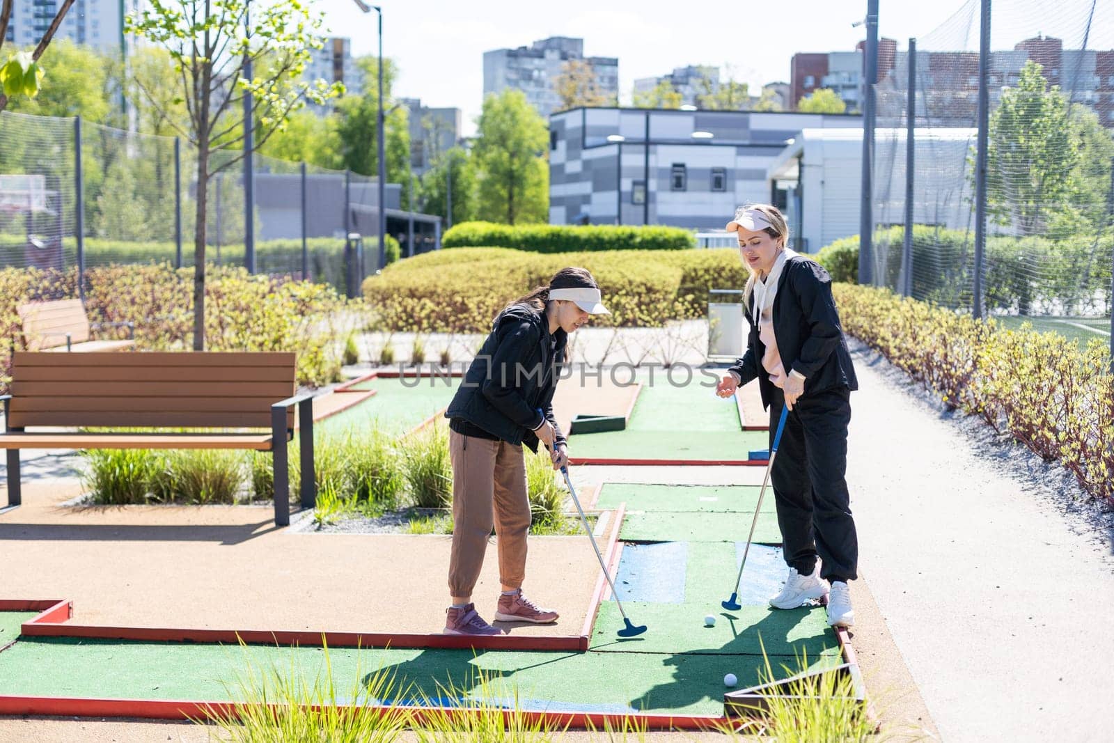 little girl and mother playing mini golf. High quality photo