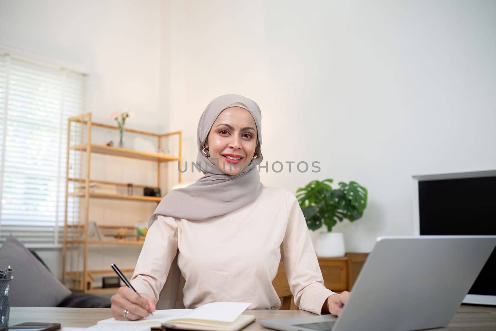 Young muslim business woman accountant working with financial document bills, calculate tax. Woman muslim freelancer paperwork at home.