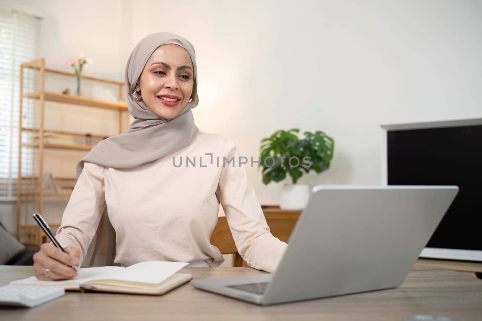 Young muslim business woman accountant working with financial document bills, calculate tax. Woman muslim freelancer paperwork at home by nateemee
