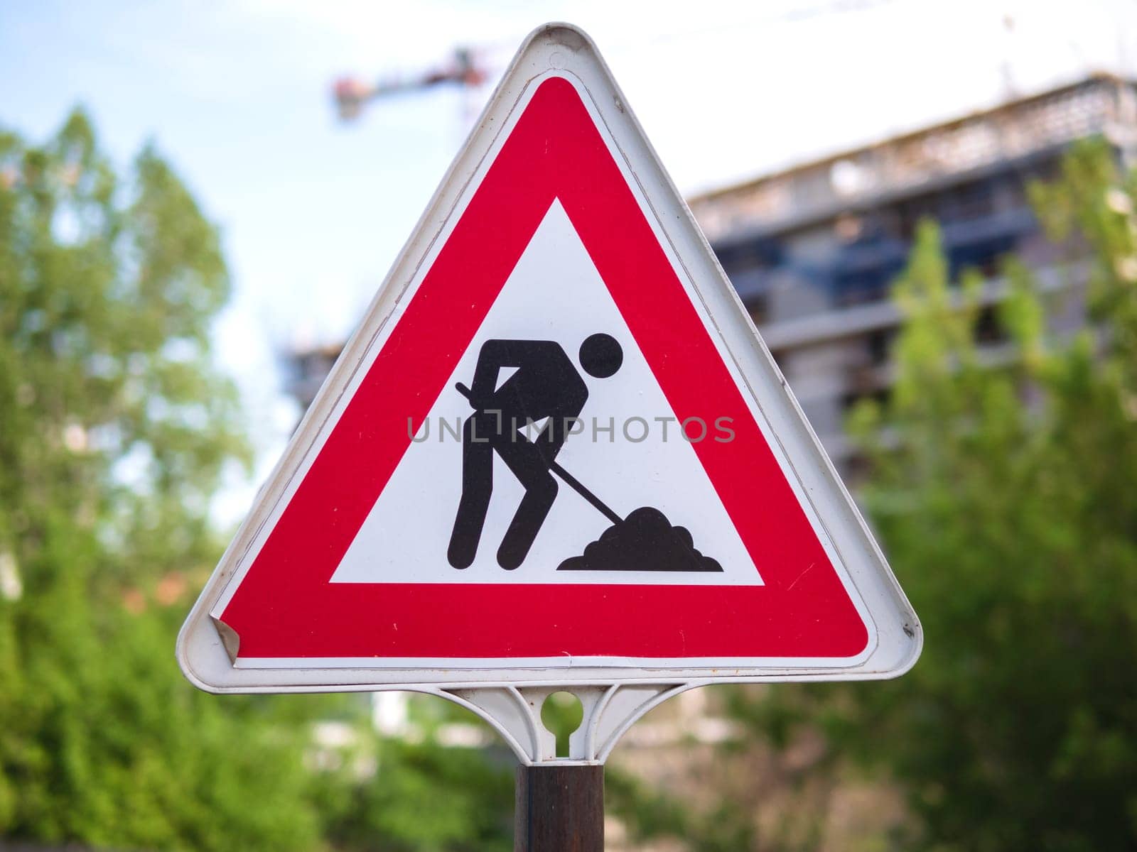 A construction sign with a triangle design. Road works sign. Red triangle sign with silhouette working person inside by jackreznor