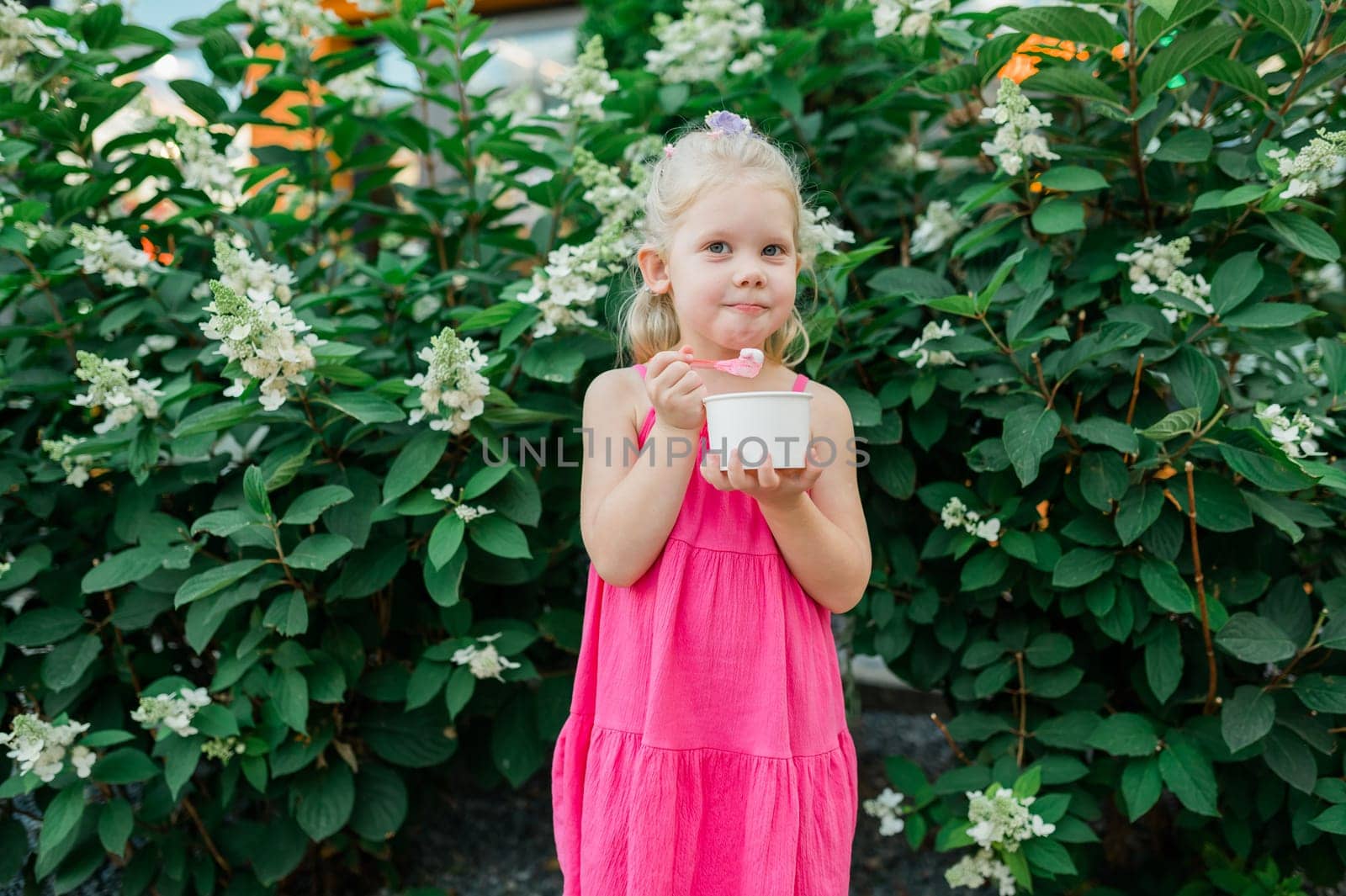 Child girl walks and have fun outdoor with cochlear implant on the head. Hearing aid and treatment concept. Copy space vertical.