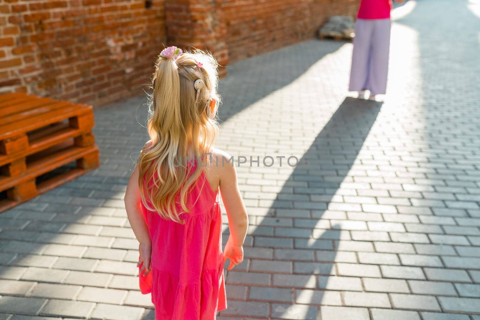 Child girl walks and have fun outdoor with cochlear implant on the head. Hearing aid and treatment concept. Copy space. Inclusion and people with disability by Satura86