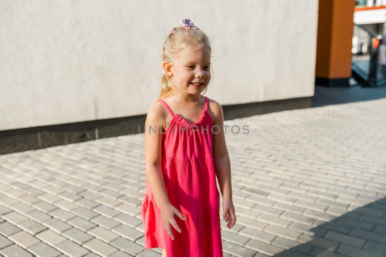 Child girl walks and have fun outdoor with cochlear implant on the head. Hearing aid and treatment concept. Copy space. Inclusion and people with disability by Satura86