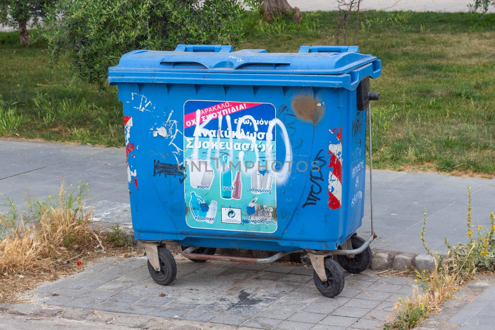 A blue trash bin stands as an essential component of urban waste management, providing a reliable solution for maintaining cleanliness and tidiness in city streets