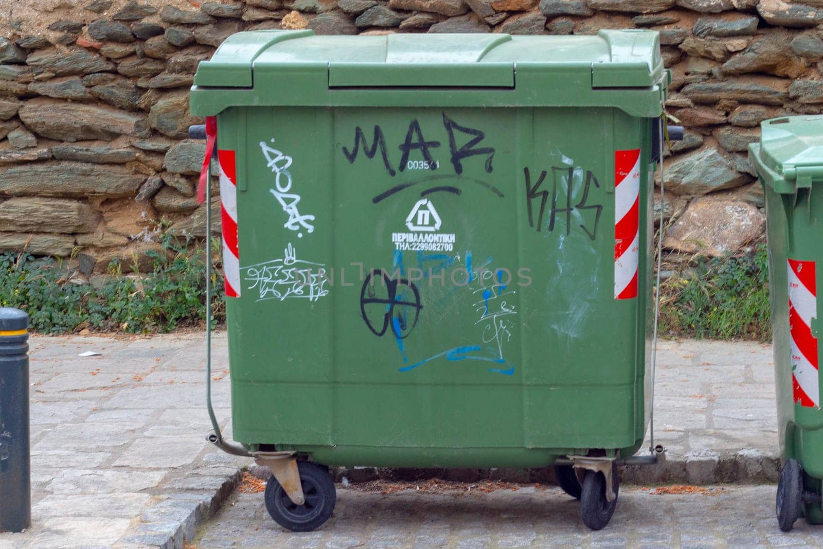 The green trash bin serves as a sustainable solution for urban waste disposal, promoting environmental consciousness and cleanliness in city environments