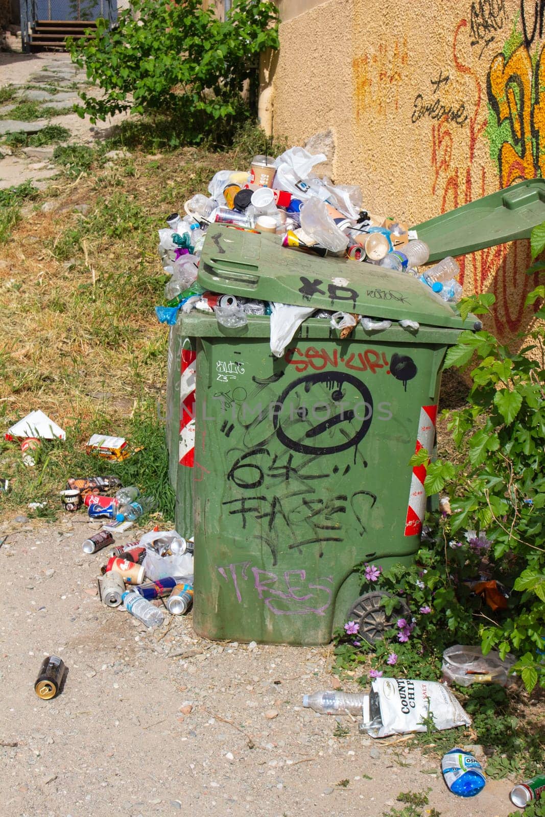 An overflowing trash bin presents a visible challenge in urban waste management, highlighting the need for increased collection and disposal efforts to maintain cleanliness in city streets