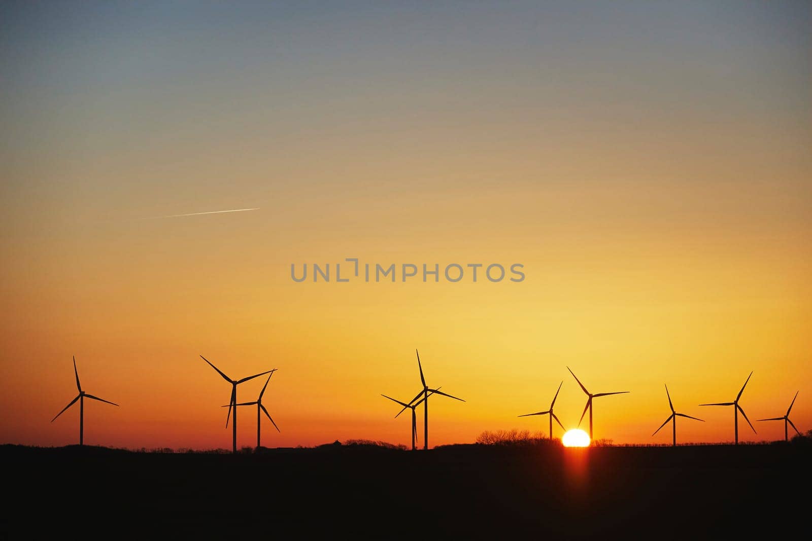 Wind turbines in the Danish countryside at sunset.