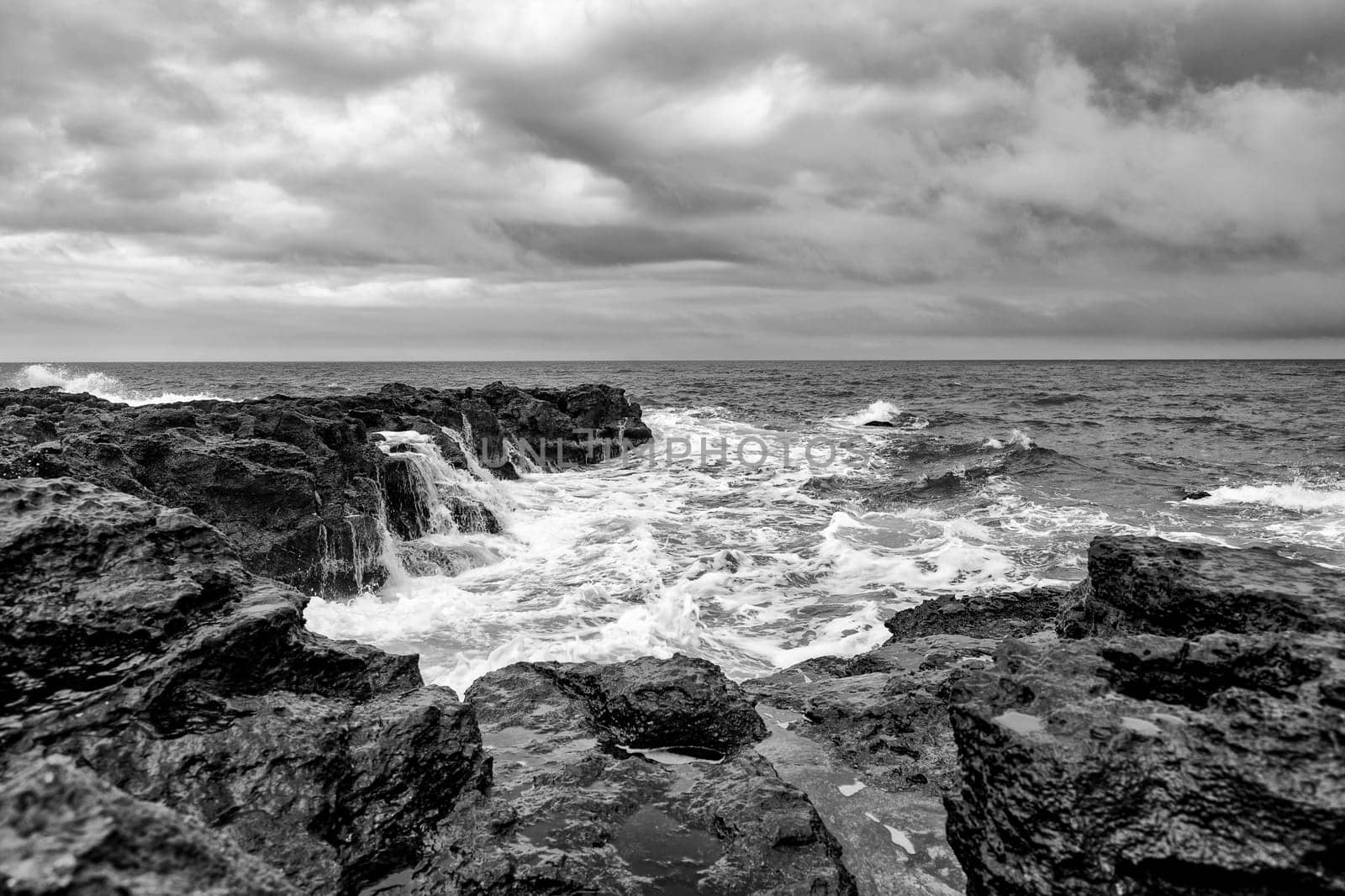 Stunning seascape with scenic clouds over the sea with rocky shore