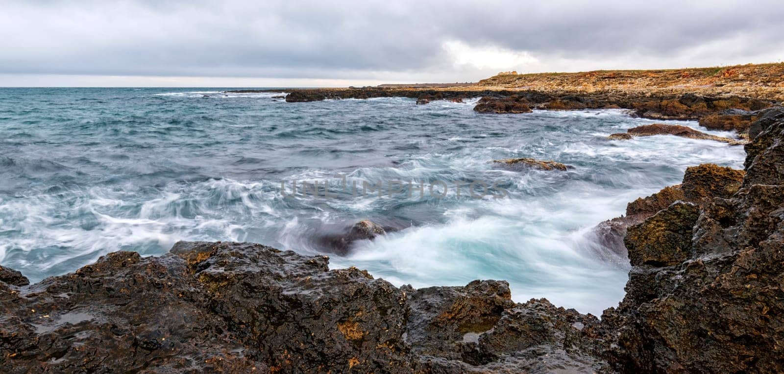 Stunning panoramic seascape with scenic clouds over the sea with rocky shore