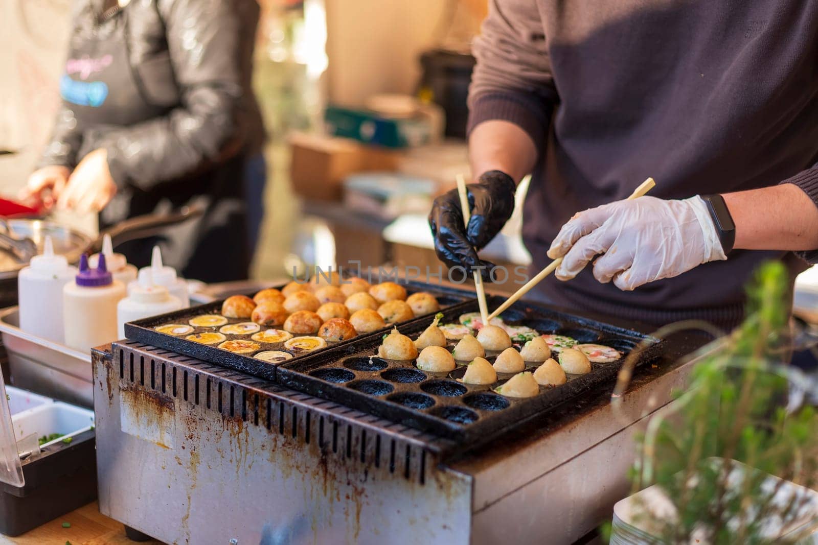 Process of cooking takoyaki balls. Japanese snacks and street food at the festival