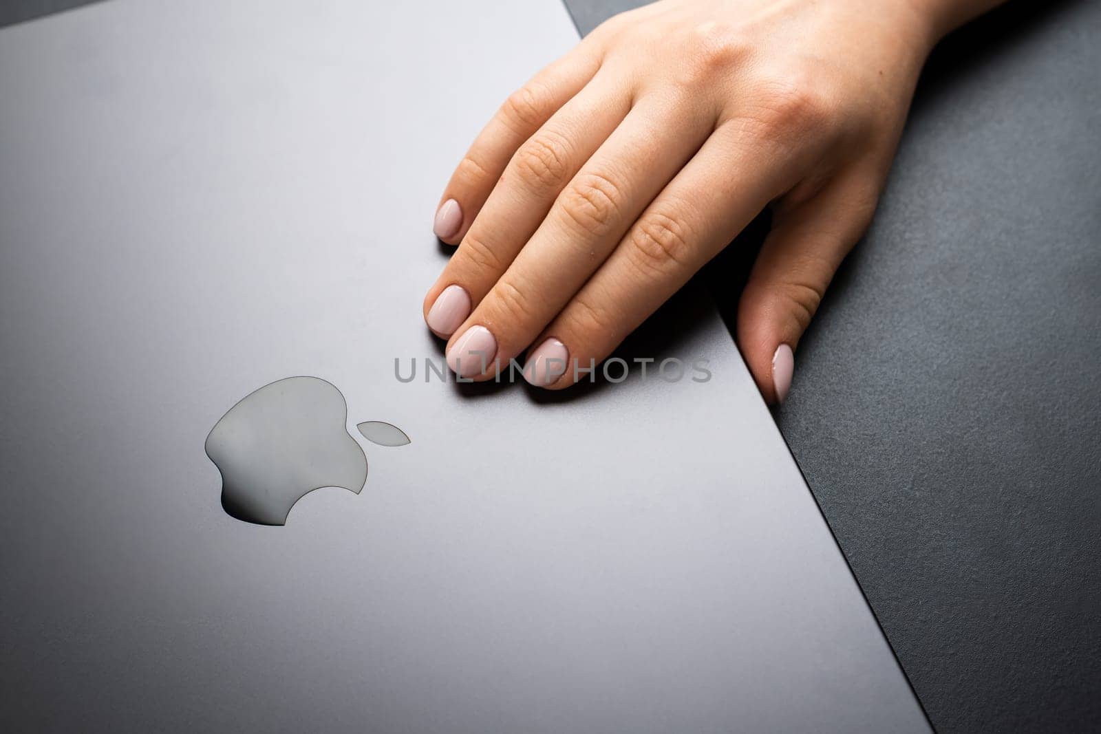 BERLIN , GERMANY - FEBRUARY 14, 2024: Woman starts her work with MacBook, opening it.