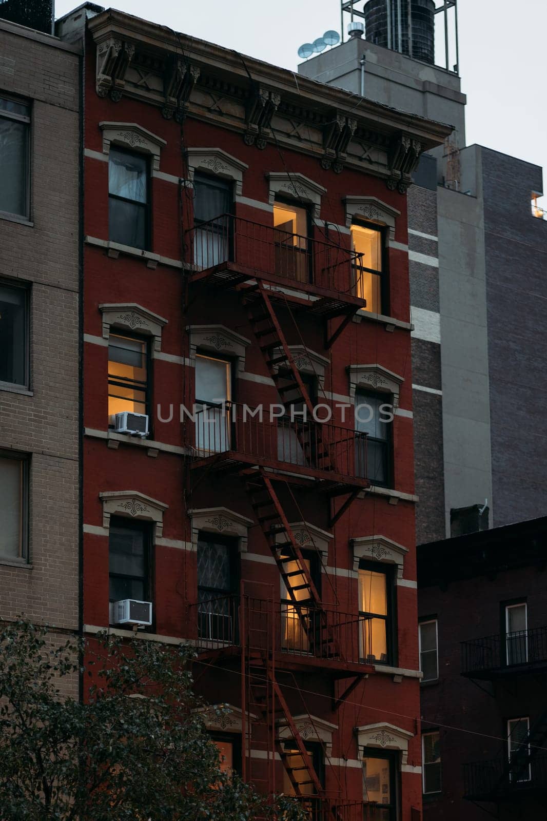 Warmly Lit Windows of a Red Brick New York Building at Dusk by apavlin