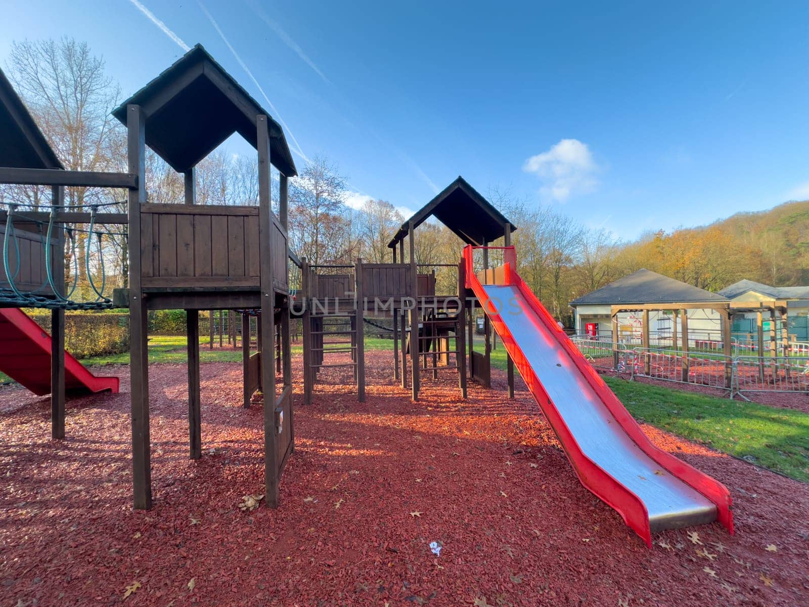 Colorful playground with climbing stairs and slides on yard in the park.