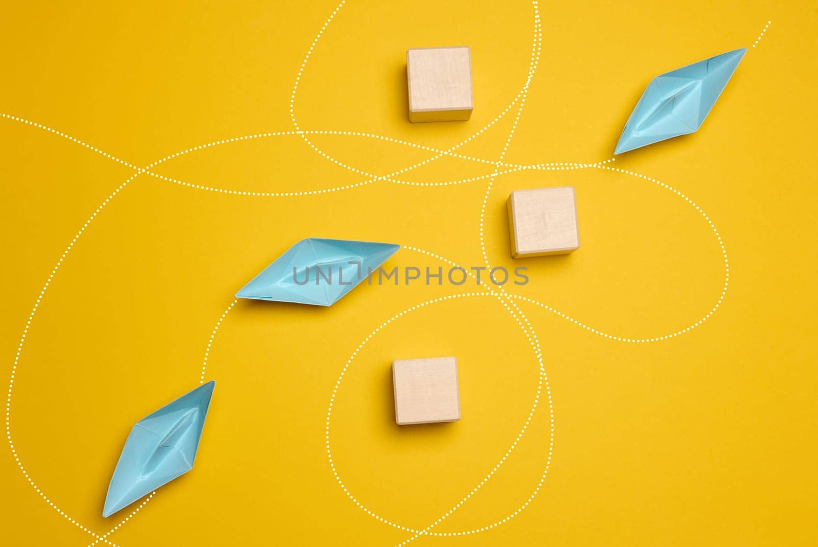 Paper boats and the trajectory of movement avoiding obstacles, yellow background