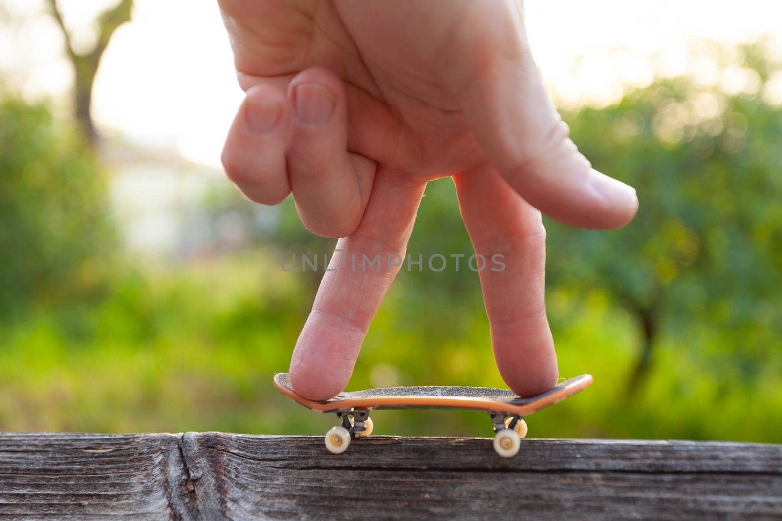 A man's fingers ride a small skateboard like a little man. High quality photo