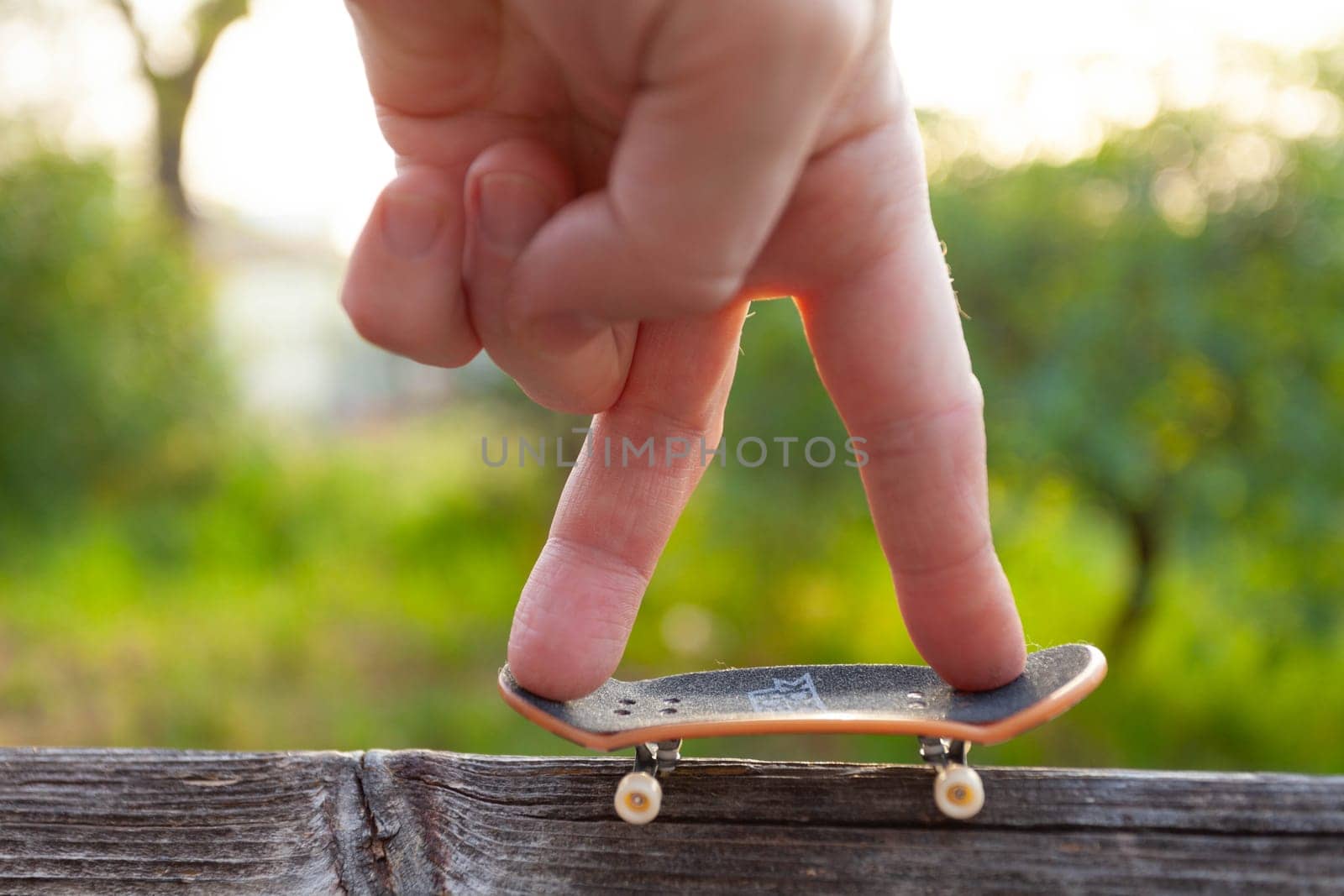 A man's fingers ride a small skateboard like a little man by gordiza