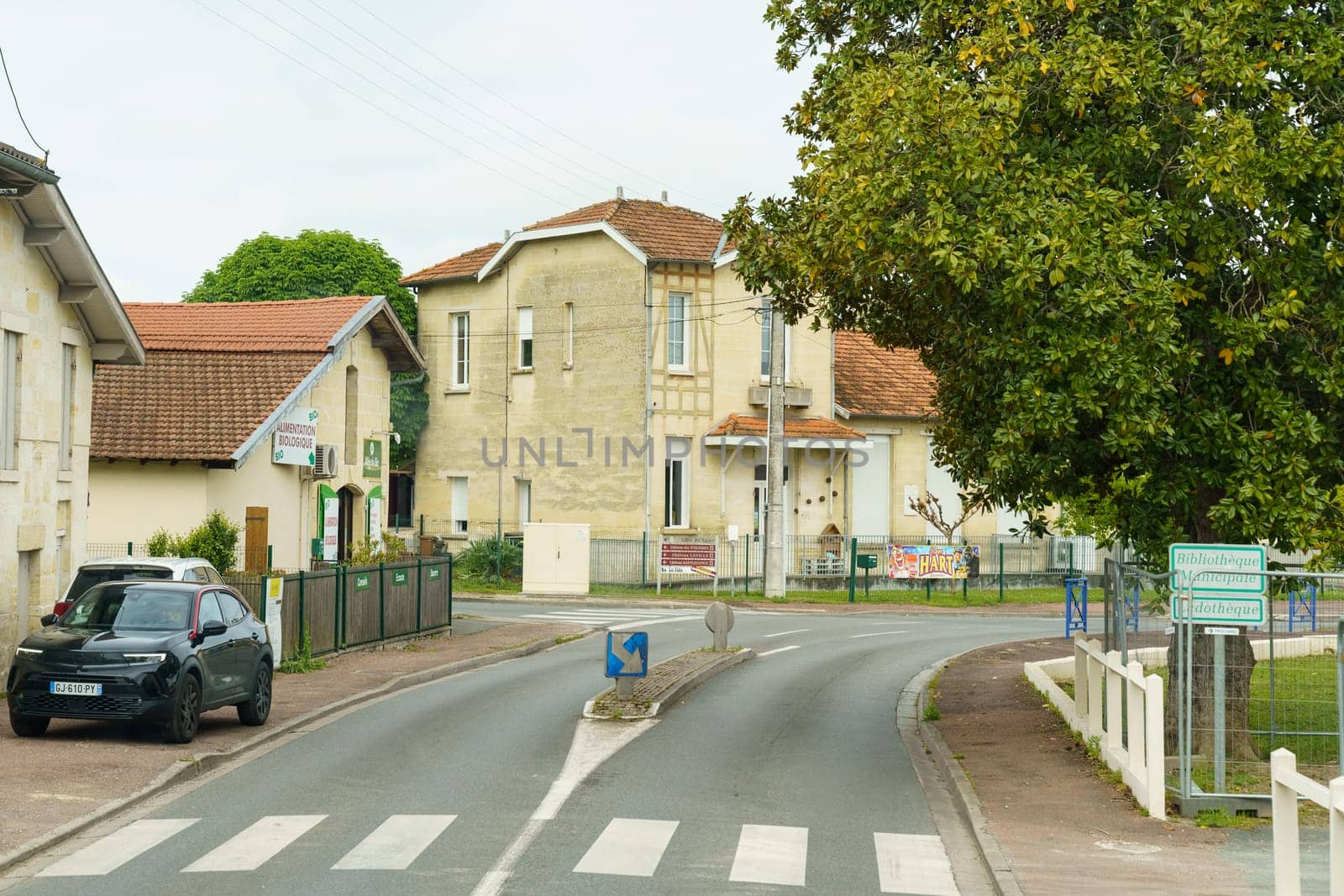 Ussel, France - April 27, 2023: A car is parked on the side of a road, surrounded by trees and grass. The vehicle shows no signs of movement or activity.
