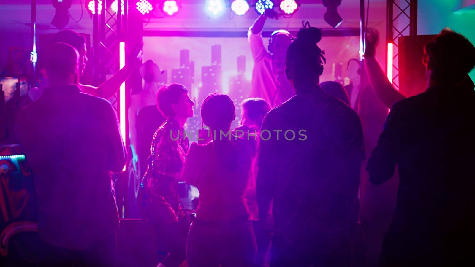 Persons at club interrupted by police lights, funky people stopping the music after seeing law enforcement officers. Group of friends running away from dance floor and nightclub. Handheld shot.