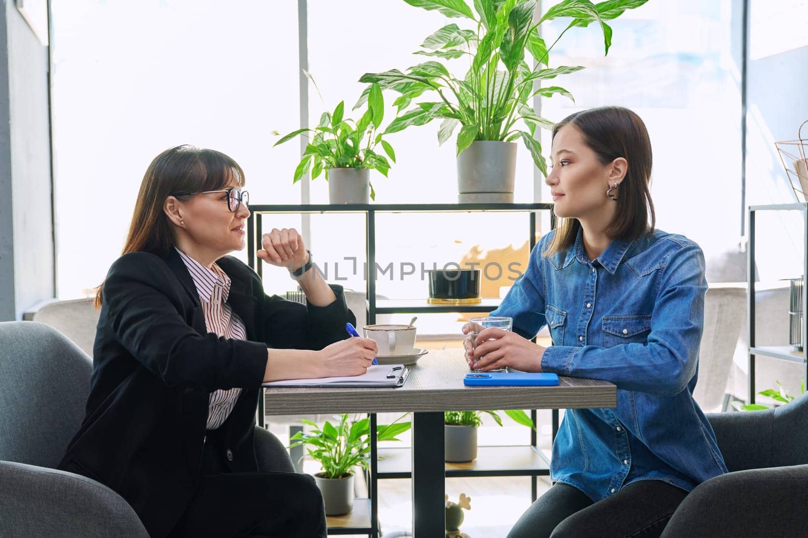 Young female patient at therapy meeting with professional psychologist, counselor, mental therapist. Psychology, psychotherapy, counseling, mental assistance, health support