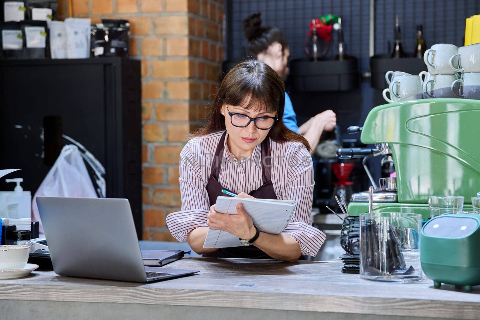 Colleagues, partners, man and woman behind counter in coffee shop by VH-studio