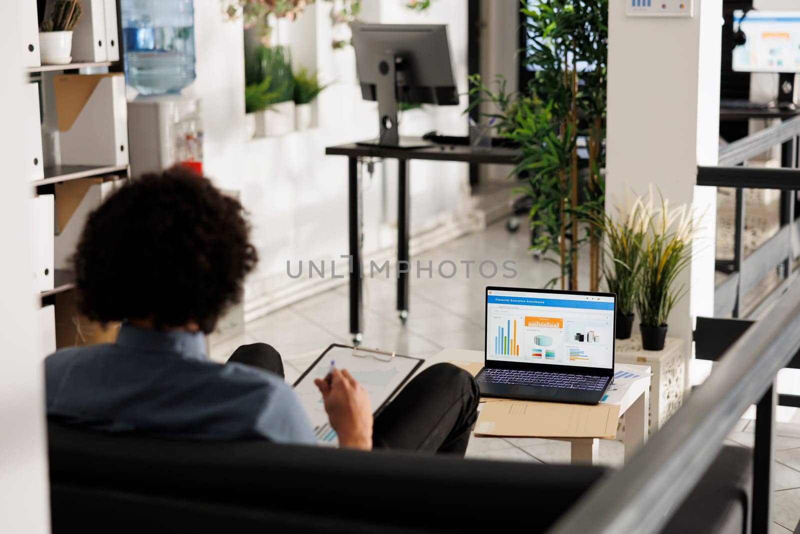 Businessman analyzing financial data on laptop screen in office by DCStudio