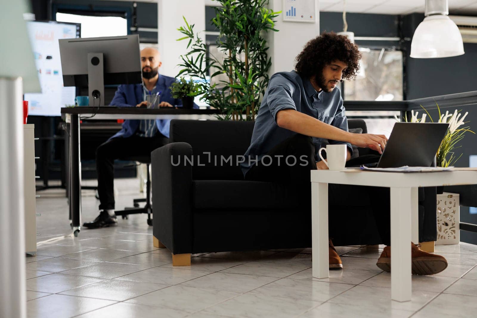 Arab start up employee working at business plan development on laptop. Marketing professional checking sales analytics report and thinking about strategy while working in office