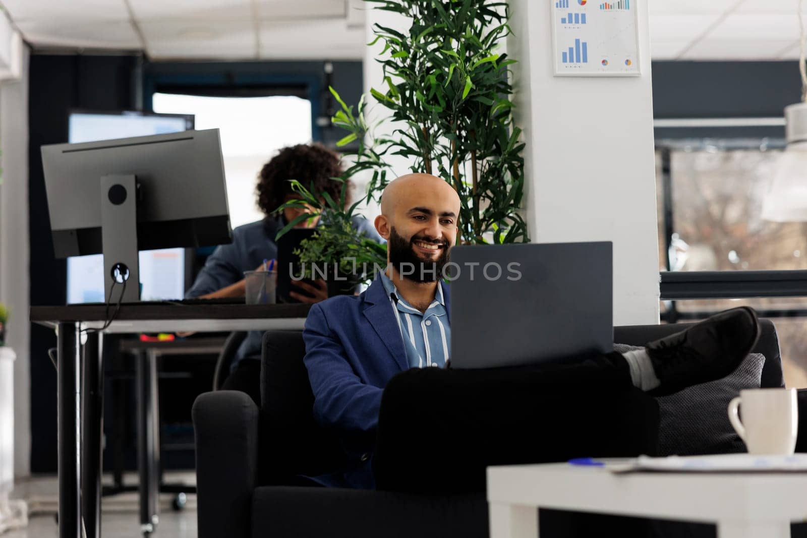 Smiling arabian businessman having videoconference with coworker by DCStudio