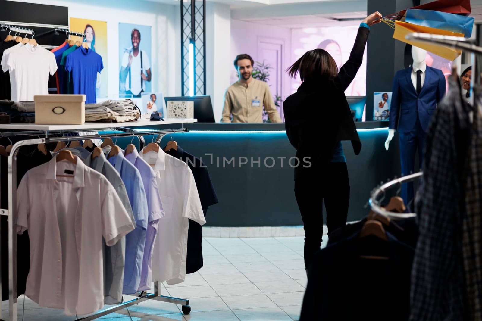 Woman dancing with bag in clothing store by DCStudio
