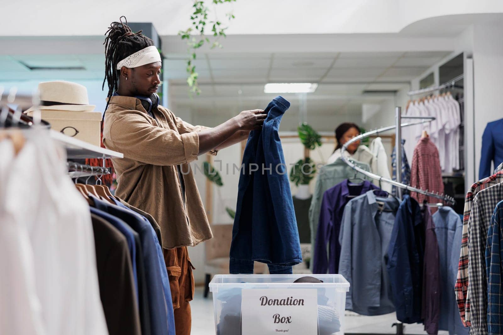 Man putting casual shirt in donation box while shopping by DCStudio