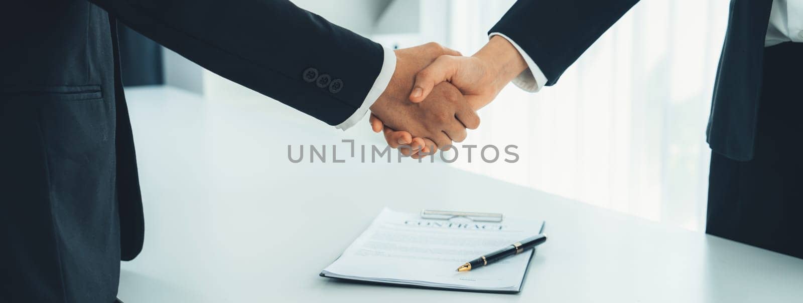 Two business executive shake hand in boardroom, sealing agreement merging two company. Handshake symbolize business partnership and cooperation. Corporate acquisition and merger concept. Shrewd