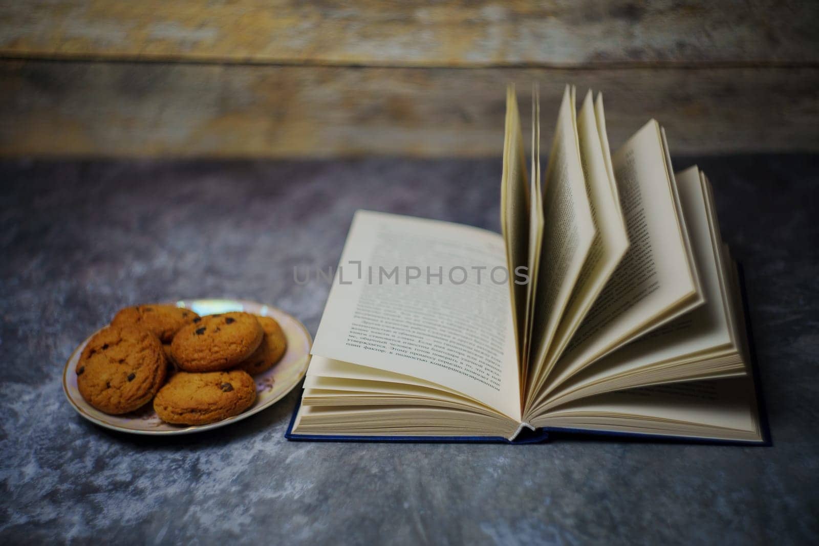 Open book next to a plate of cookies. High quality photo