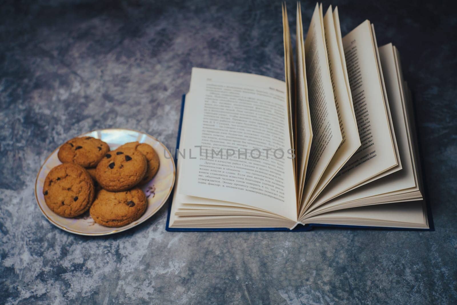 Open book next to a plate of cookies. High quality photo